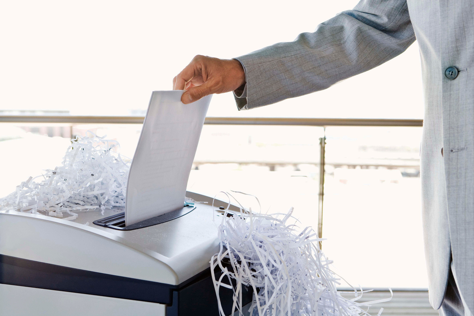 Businessman with overflowing paper shredder